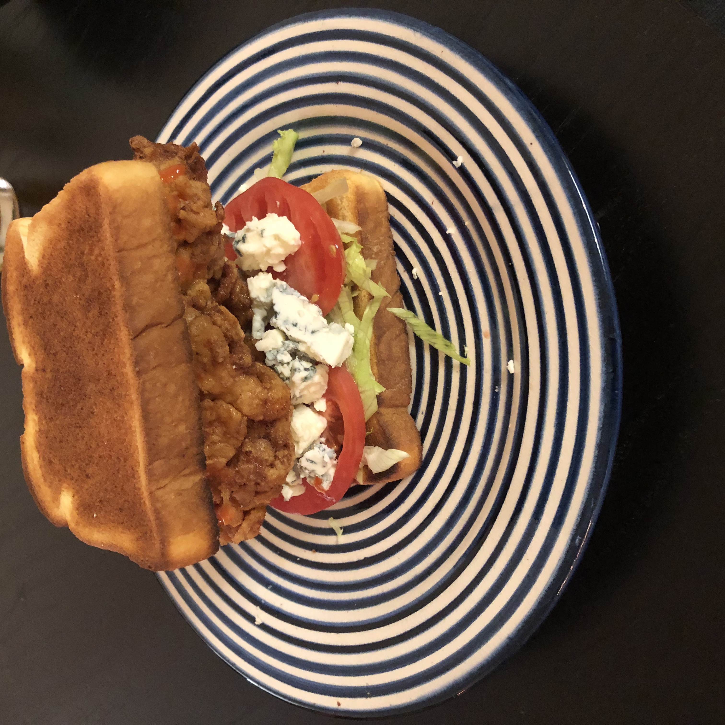 A Buffalo chicken sandwich sitting on a plate